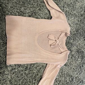 Rose colored open back sweater with bow detail.